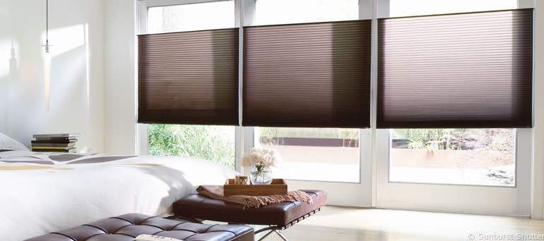 Contemporary Phoenix bedroom with tall windows and brown honeycomb shades.