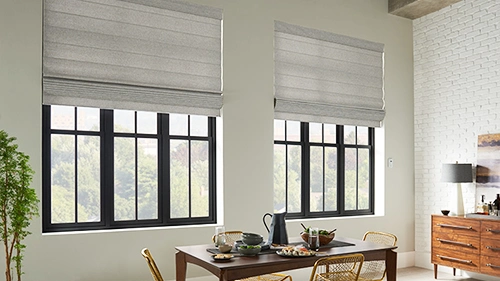 Roman shades in light gray on two large black lined windows 
