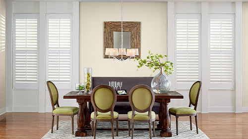 Tall white polywood shutters in a large dining room