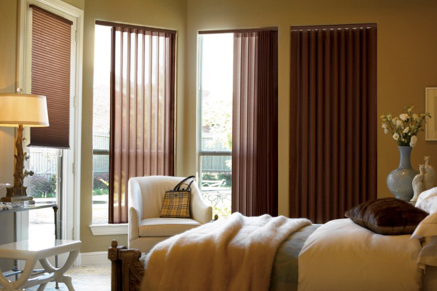Choose durable and high-quality fabric or vinyl vertical blinds in Phoenix. Maroon fabric vertical blinds inside a bedroom