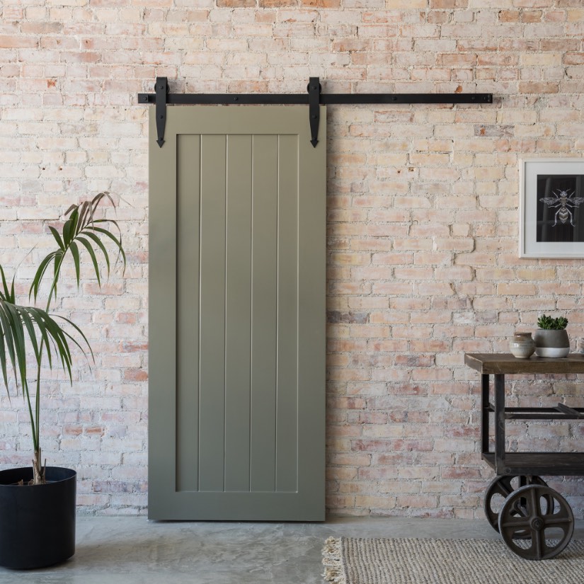 Barn door against a whitewashed brick wall