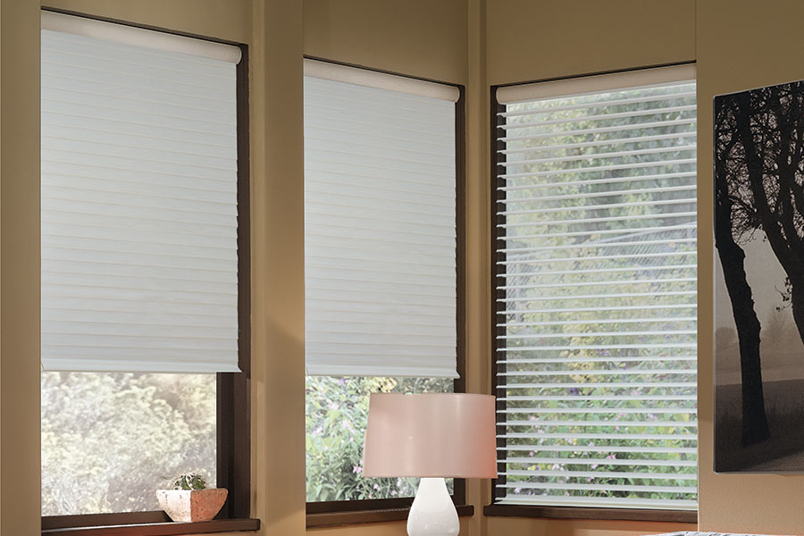 Schedule your smart motorized shades to open and close whenever you want. Gray sheer shades on windows in the corner of a modern living room