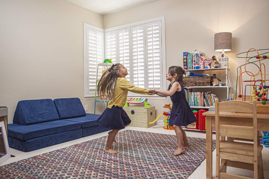 Choose Polywood shutters for durable, kid-friendly great room window treatments in Phoenix. Polywood shutters on multiple windows in a sitting area