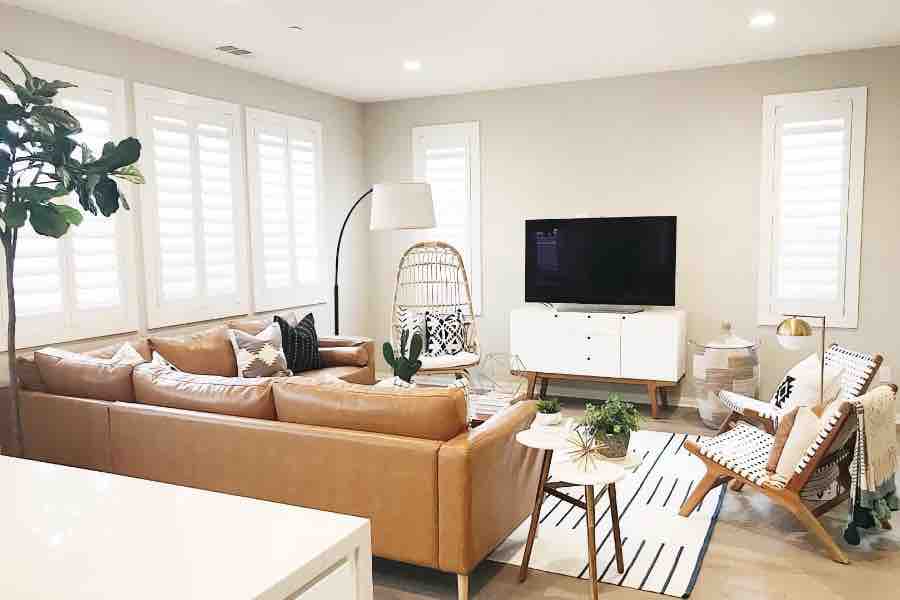 Polywood shutters keep sun glare and drafts at bay when you're relaxing in your family room. White Polywood shutters on living room windows