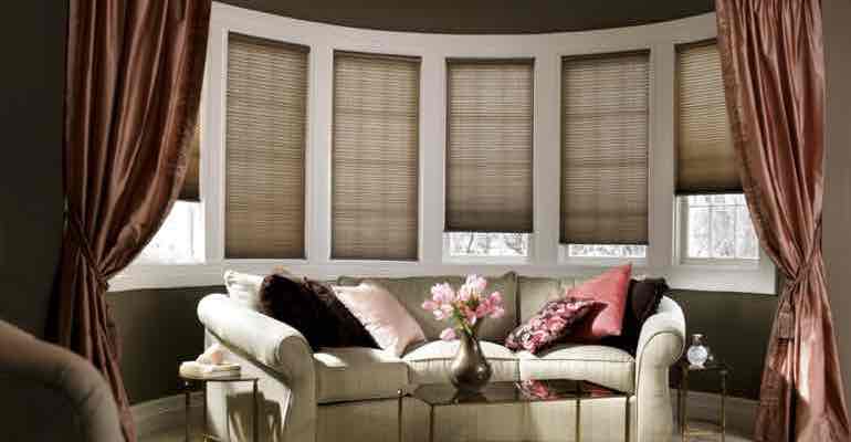 Vertical cellular shades in lounge bow window.