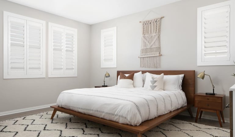 Open shutter louvers will help any Phoenix room feel larger. Plantation shutters in a model home bedroom.