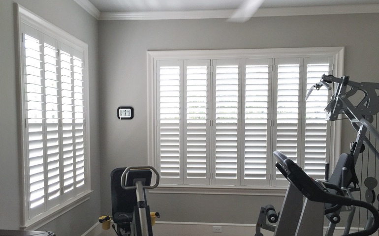 Weatherstripping window coverings are especially important in rooms with windows on multiple walls. Phoenix fitness room with shuttered windows.