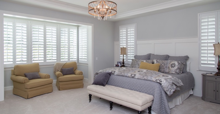 Indoor shutters offer subtle fashion. White shutters in Phoenix bedroom.