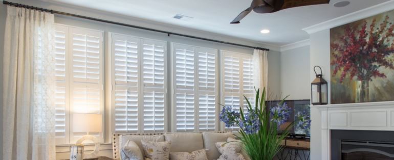 Polywood shutters can be custom made to fit any specialty window type. Polywood shutters in a living room.