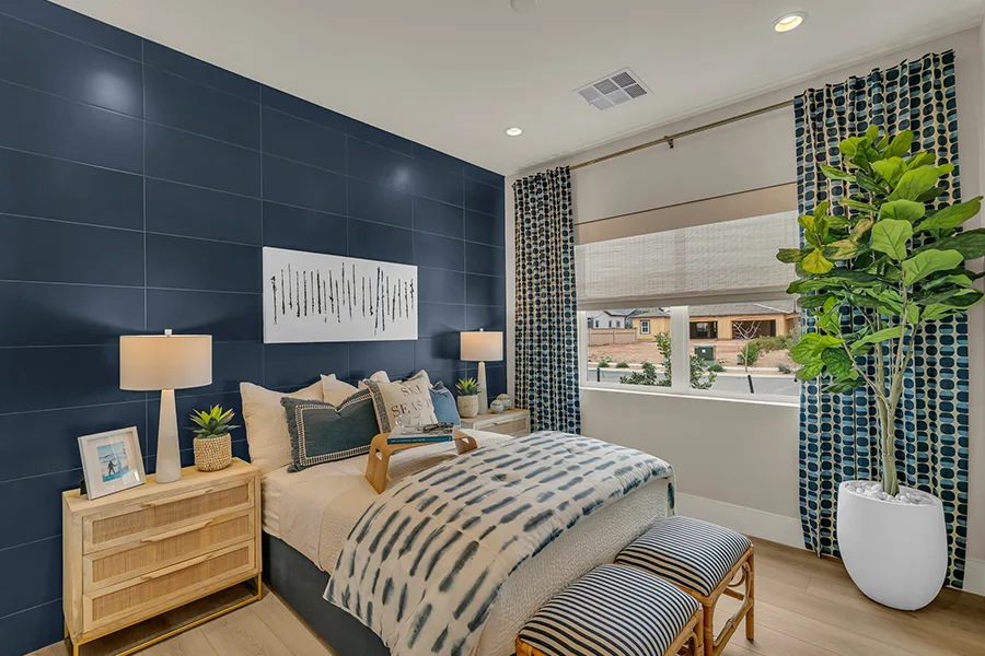 Talk to your window treatment consultant about how much light you want to block with your natural woven shades and if you want to pair them with other treatments. White woven shades halfway down over a bedroom window and paired with blue drapes Millicent Parsons