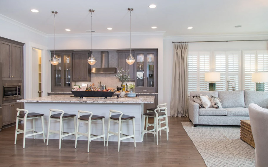 Illuminate your home with custom interior shutters in Phoenix. White arched shutters in a white kitchen with lots of light.