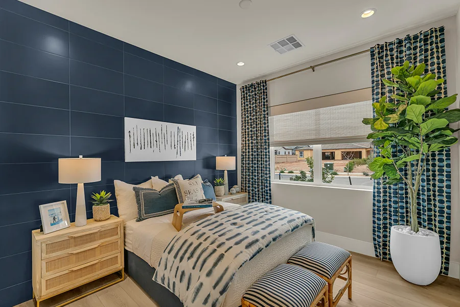 Blue patterned drapes on a window in a blue and white bedroom